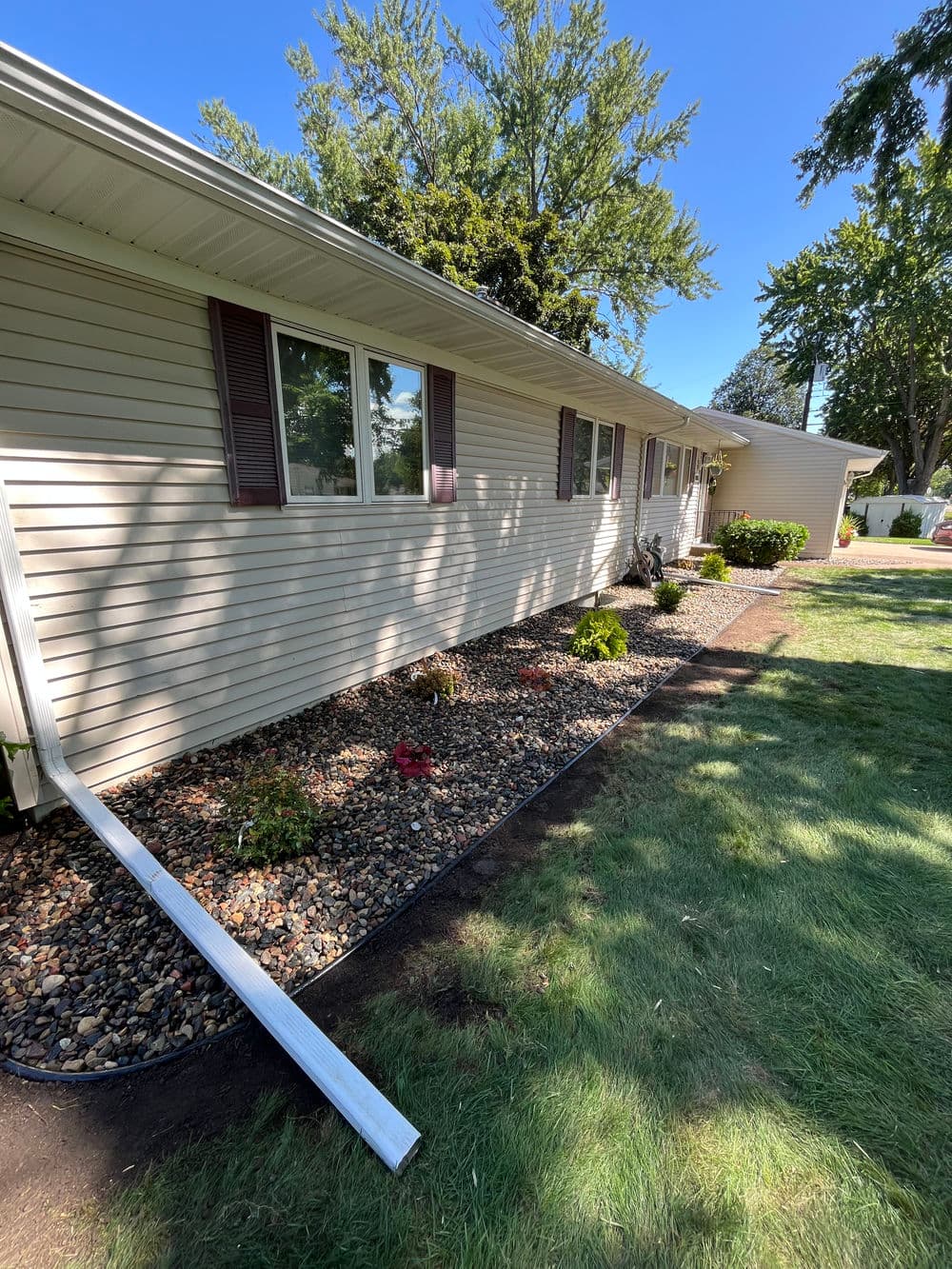 Single-story home exterior with landscaped garden and clear blue sky.